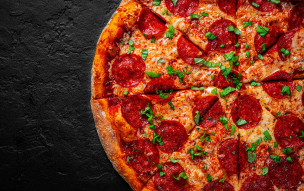 Pepperoni Pizza with Mozzarella cheese, salami, Tomato sauce, pepper, Spices. Italian pizza on Dark grey black slate background - Фото, зображення