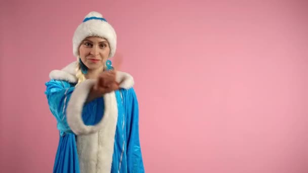 Санта-Жінка в синьому костюмі криштм не показує жесту з пальцем на фотоапараті на рожевому фоні, серйозна жінка демонструє емоційну продуктивність, дивлячись на камеру. Поняття емоцій і підписів - Кадри, відео