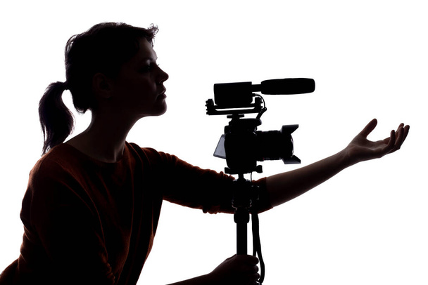 Silhouette of a female indie filmmaker, online content creator or casting director with a camera and mic okking stressed out - Zdjęcie, obraz