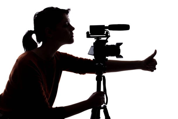 Silhouette of a female indie filmmaker, online content creator or casting director with a camera and mic on a white background - Foto, imagen