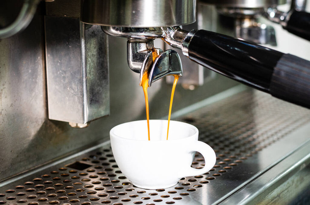 Espresso schot uit koffiezetapparaat in coffeeshop. - Foto, afbeelding