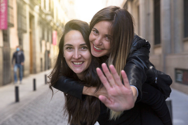Portrét dvou usmívajících se dívek bavících se ve městě. - Fotografie, Obrázek