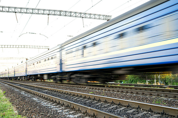 Vonat kék személygépkocsikkal, amelyek nagy sebességgel elmosódnak - Fotó, kép