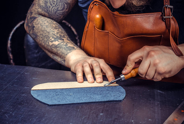 Кожаный ремесленник, создающий новое производство кожи в своем кожаном магазине - Фото, изображение