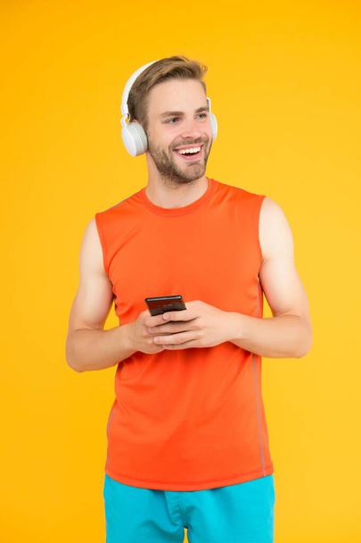 Inspiration for blogging. athletic guy in sportswear. new digital technology. happy young man in headphones. modern sport life. fitness mobile app. listen to music. sportsman use phone on workout - Foto, Imagem