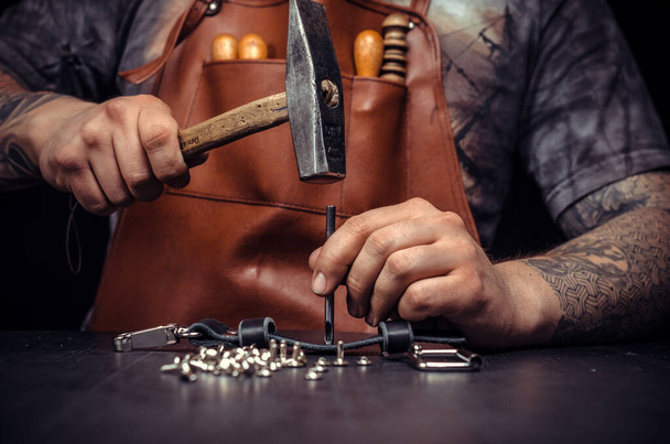 Кожаный Скиннер работает над новым кожаным изделием в мастерской - Фото, изображение
