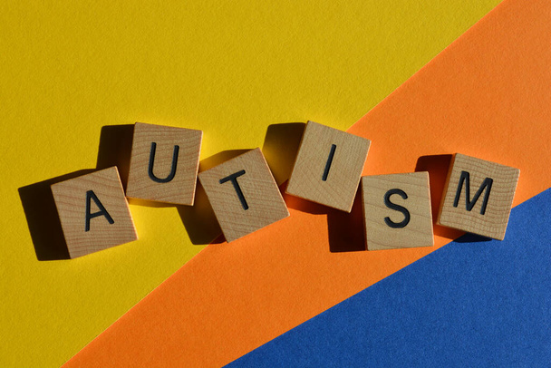 Autismo, palavra em letras do alfabeto de madeira isoladas sobre fundo colorido - Foto, Imagem