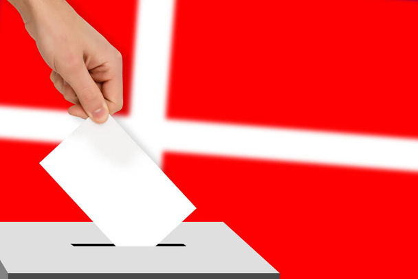 Hand lässt den Stimmzettel vor dem Hintergrund der Flagge fallen, Konzept der Landtagswahlen, Volksabstimmung - Foto, Bild