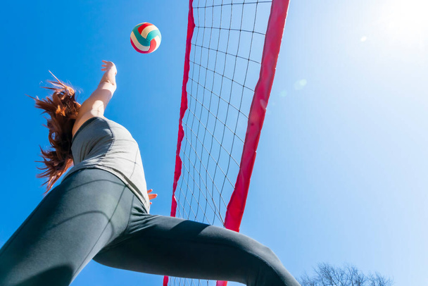 A redhead fitness model preparing to play volleyball - Zdjęcie, obraz