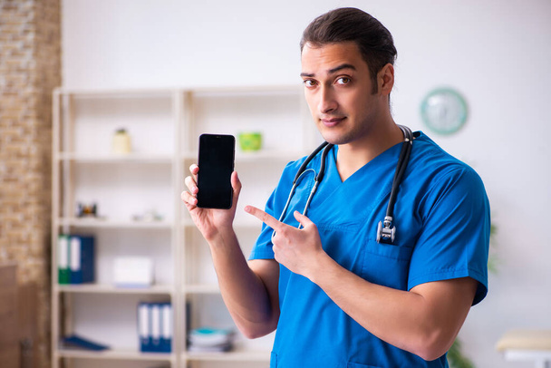 Mladý lékař pomocí smartphone v telemedicíně koncept - Fotografie, Obrázek