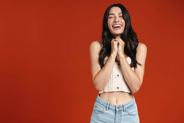 Image of young happy woman laughing and looking at camera isolated over red background - Foto, afbeelding
