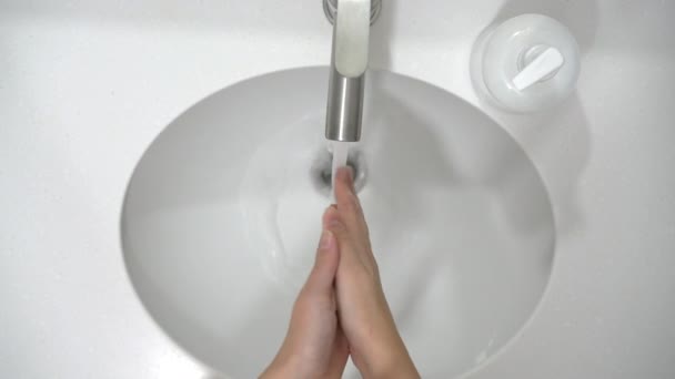 Coronaviruspreventie. Een vrouw wast zijn handen grondig met zeep en warm water thuis. - Video