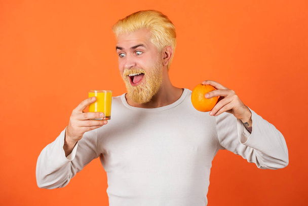 Funny excited man drinking the orange juice. - Zdjęcie, obraz