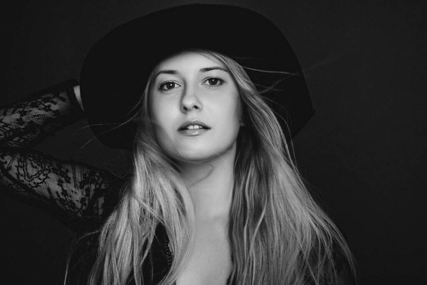 Beautiful blonde woman wearing a hat, artistic film portrait in black and white for fashion campaign and beauty brand - Fotoğraf, Görsel
