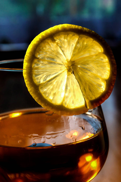A slice of lemon on a glass with cognac - Foto, afbeelding
