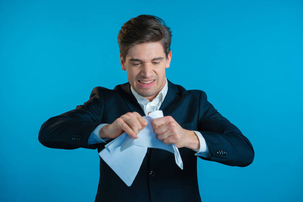 Angry businessman tearing contract in pieces. Furious male office worker throwing crumpled paper, having nervous breakdown at work, screaming in anger, stress management. - Foto, imagen