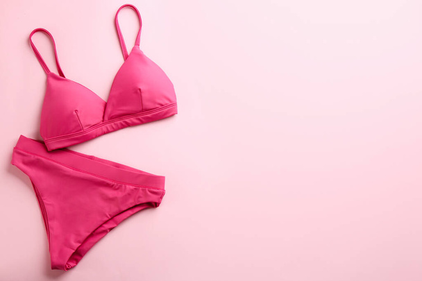 Beautiful bikini on pink background, top view. Space for text - Zdjęcie, obraz
