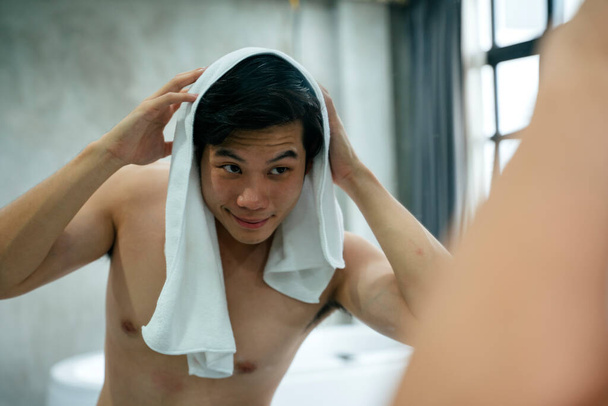 Asian young man cleaning hair with towel after taking shower. - Photo, Image
