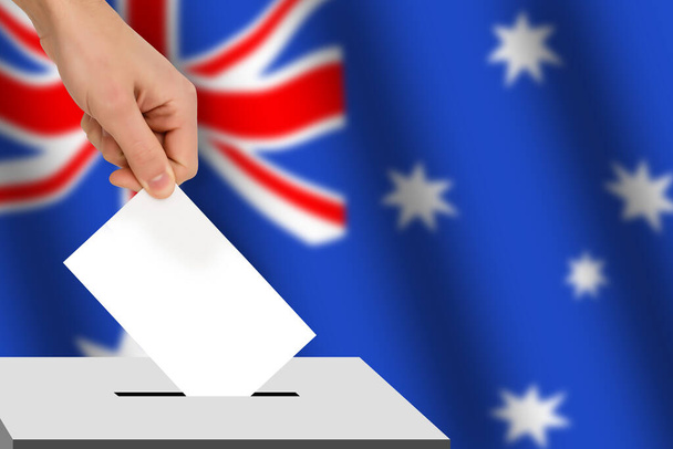 Hand lässt den Stimmzettel vor dem Hintergrund der Flagge fallen, Konzept der Landtagswahlen, Volksabstimmung - Foto, Bild