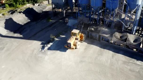 Drone Shot de la fábrica de asfalto con un cargador de ruedas amarillo  - Imágenes, Vídeo