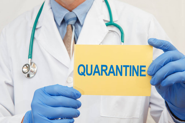 Doctor holding sign with text QUARANTINE closeup. Quarantine during coronavirus outbreak - Фото, изображение