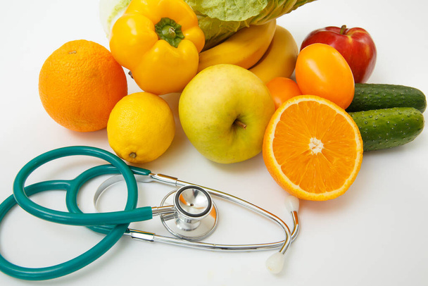 Nutrition and healthy eating. Fruits, vegetables, juice and stethoscope - Foto, afbeelding