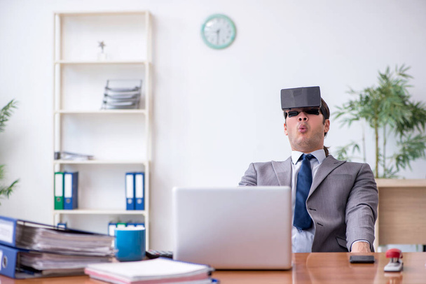 Young male employee wearing virtual glasses in the office - Fotoğraf, Görsel