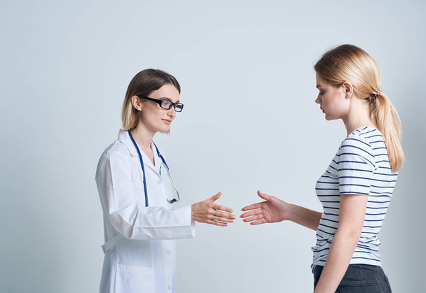 Naislääkäri ja potilas kättelevät kevyellä taustalla kommunikoiva lääke - Valokuva, kuva