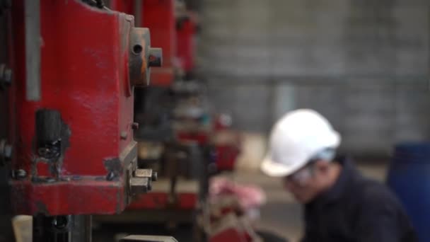 Profesyonel Asyalı işçi Depo fabrikasında büyük makineler üretiyor. Konsept Mühendisi Fabrikada güvenlik ile birlikte çalışır ve kontrol eder. - Video, Çekim