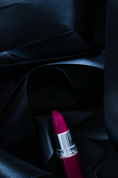 Rouge à lèvres violet sur fond de soie noire, maquillage de luxe et cosmétiques de beauté - Photo, image