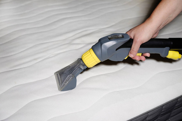 cleaning the mattress with a vacuum cleaner - Foto, Imagen