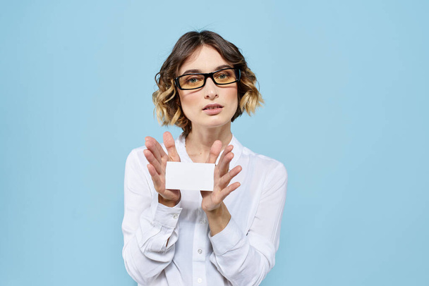 Nő visel névjegykártya szemüveg a kezében a kék háttér Másolás tér kivágott nézet - Fotó, kép