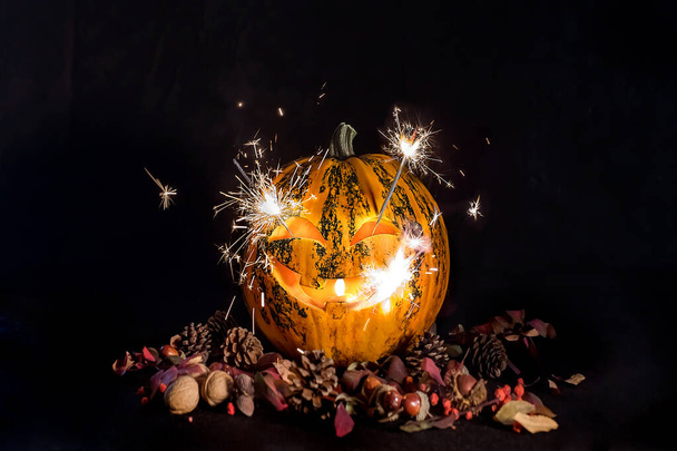 Carved pumpkins for Halloween, Jack's head is on the table. Fireworks in a pumpkin. Dark background. - Fotó, kép