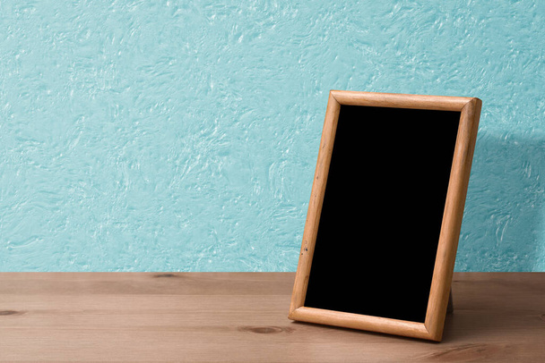 moldura de madeira da foto na tabela, parede azul - Foto, Imagem