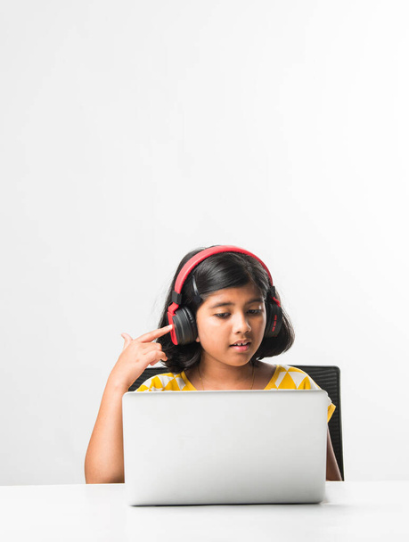 Pretty stylish Indian asian schoolgirl studying attending online lesson at home, social distance during quarantine, self-isolation, online education concept, home schooler - Photo, image
