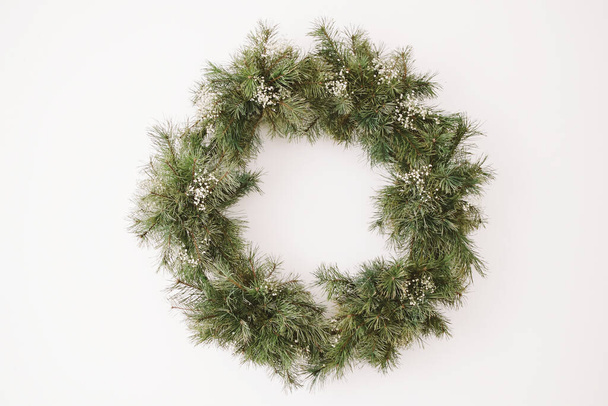 Wreath of spruce on white background. Christmas decorations. New Year holiday composition. Frame wreath mock up. Copy space  - Photo, image