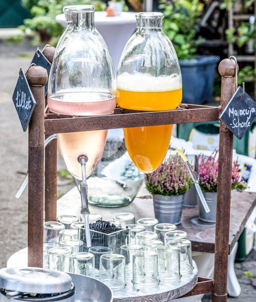 Vintage shabby chic old hanging bottles with wine and maracuja juice on a wedding a party - Foto, Bild