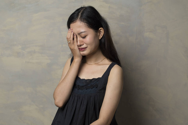 Sad young Asian woman cry with palm to face - Photo, Image