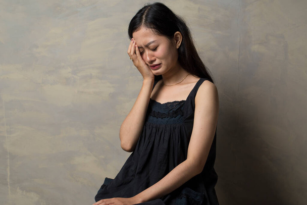 Smutna młoda Azjatka płacze dłonią w twarz - Zdjęcie, obraz