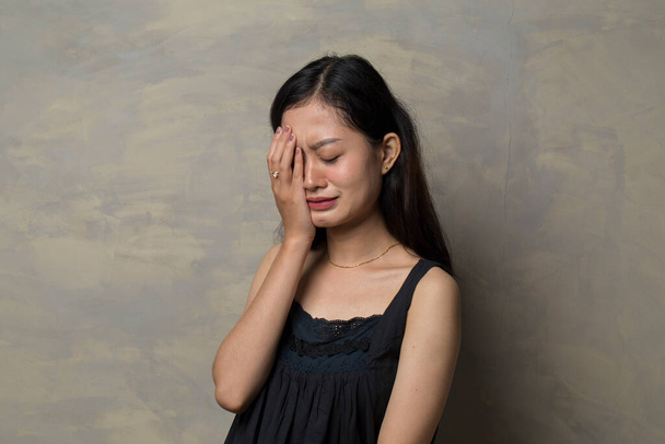 Triste giovane donna asiatica piangere con palma a faccia - Foto, immagini