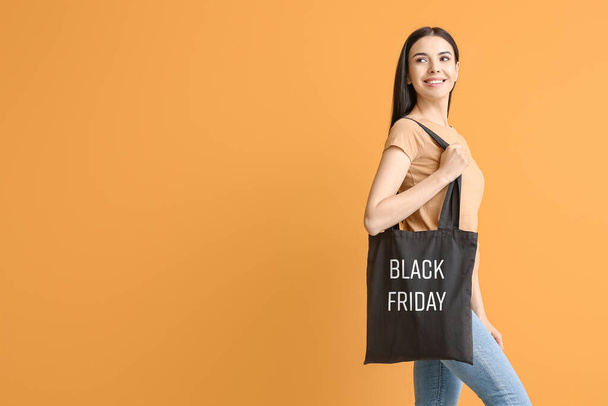 Jeune femme avec sac écologique sur fond de couleur. Vente Black Friday - Photo, image