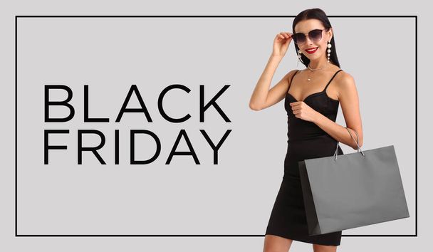 Beautiful young woman with shopping bag on light background. Black Friday sale - Photo, image