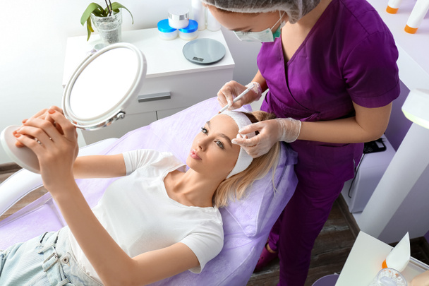 Frau unterzieht sich kosmetischem Eingriff im Schönheitssalon - Foto, Bild