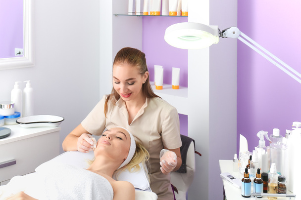 Woman undergoing cosmetic procedure in beauty salon - Photo, Image
