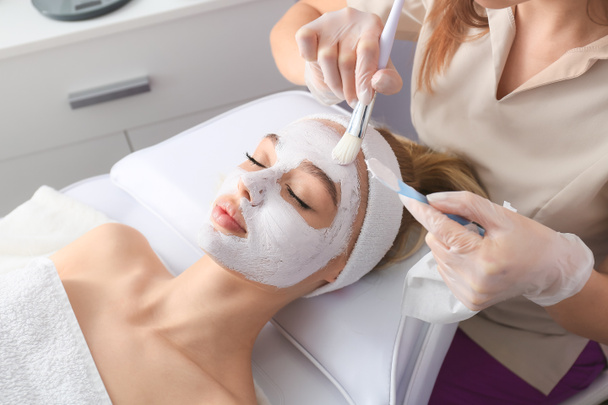 Косметолог наносить маску на обличчя жінки в салоні краси
 - Фото, зображення