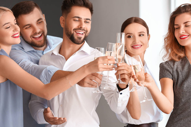 Giovani che bevono champagne saporito a festa in ufficio - Foto, immagini