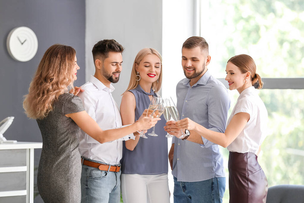 Jongeren drinken lekkere champagne op het feest op kantoor - Foto, afbeelding