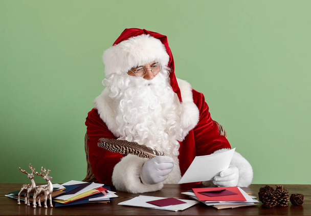 Kerstman maken lijst van geschenken op kleur achtergrond - Foto, afbeelding