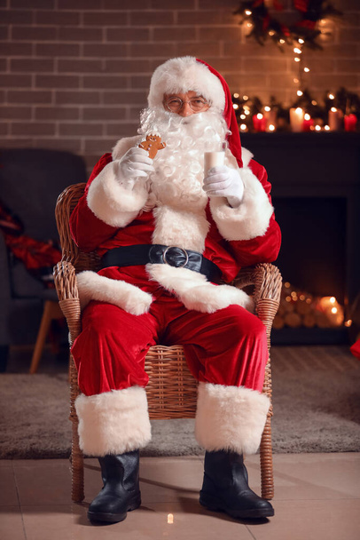 Santa Claus with gingerbread cookies and milk at home on Christmas eve - 写真・画像