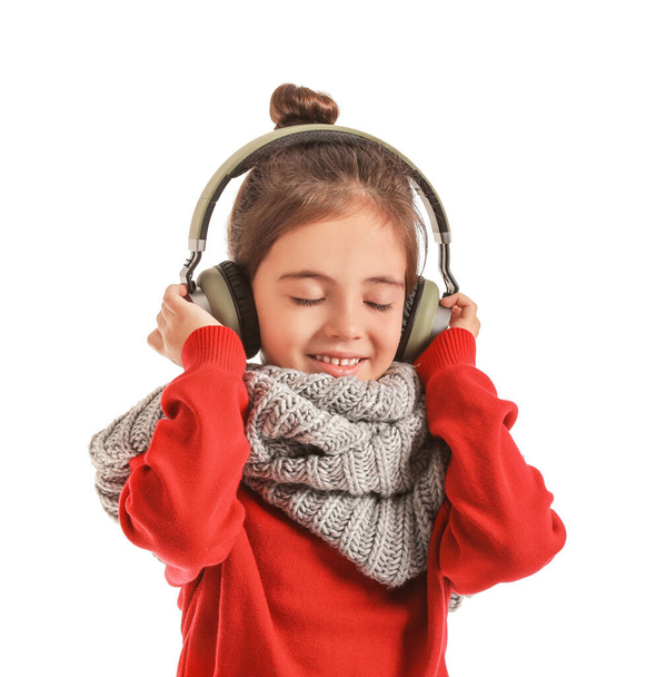 Little girl listening to music on white background - Фото, изображение